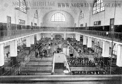 View of the interior of the main building at Ellis Island, showing the detention pens and emigrants passing doctors for examination